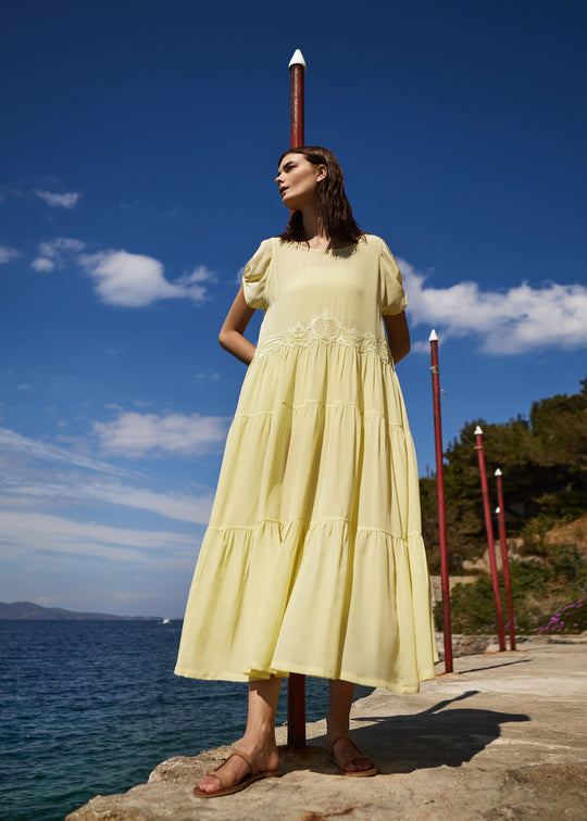 Girl in yellow dress standing by the sea